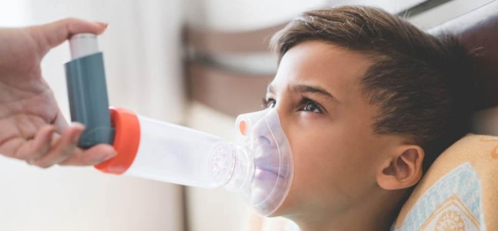 Child using inhaler with spacer