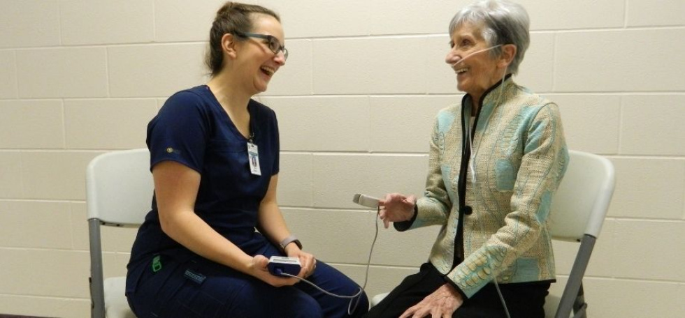 Woman wearing oxygen chatting with nurse