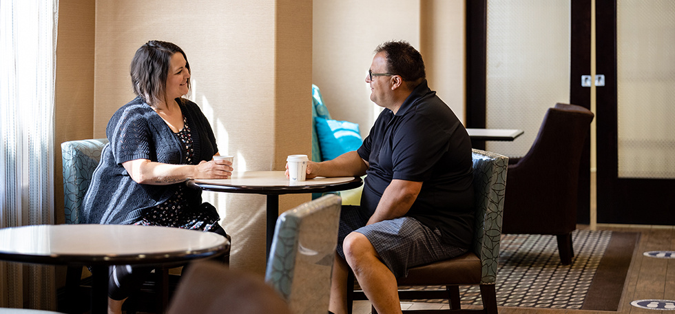 Man and woman sitting together talking over coffee